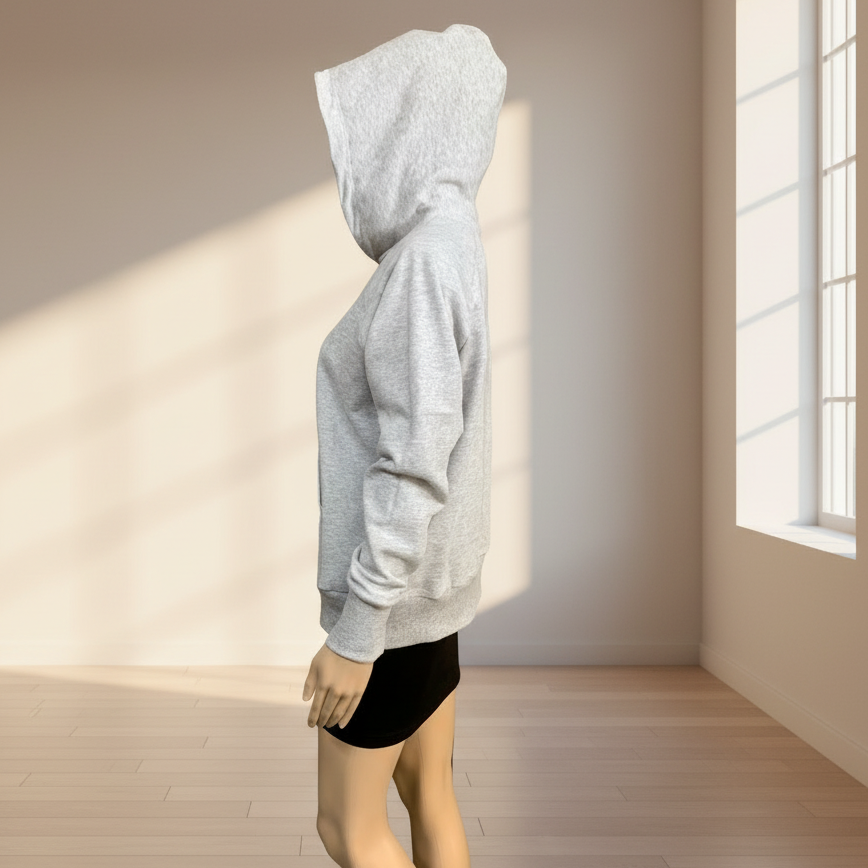 Mannequin wearing a gray hoodie in a room with a window and wooden floor.