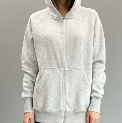 person wearing a light gray hoodie and black shorts on a plain background