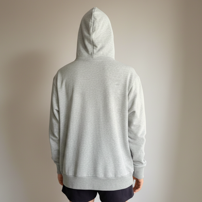 Person wearing a gray hoodie from behind on a plain background