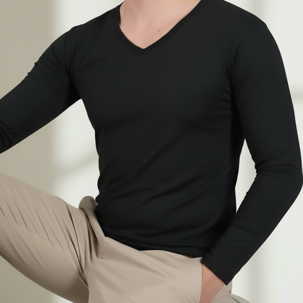 Person wearing a black t-shirt and beige pants against a neutral background