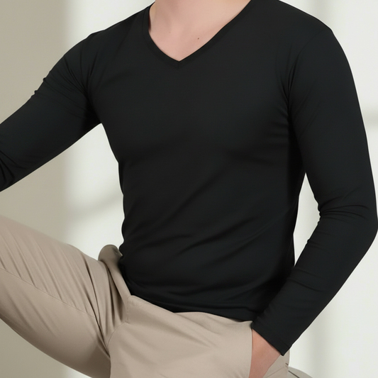 Person wearing a black t-shirt and beige pants against a neutral background