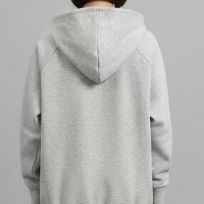 person wearing a gray hoodie on a plain gray background