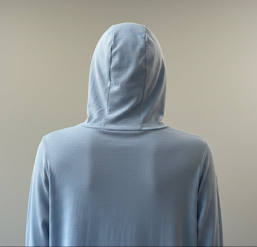 Person wearing a light blue hoodie with a blurred indoor background