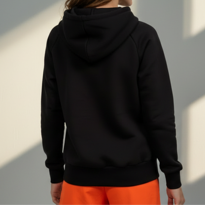Person wearing a black hoodie with a light gray background